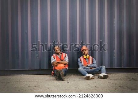 Human trafficking,illegal labor concept : Two African American workers working in the illegal immigration industry sit sad and hopeless and sent a judgment to return to the country of origin. Royalty-Free Stock Photo #2124626000