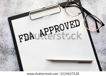Businessman putting a card with text FDA Approved in the pocket.