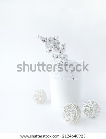 White carved decorative flower pot and white dried flowers.