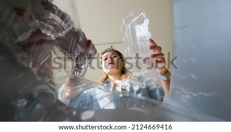 Asian woman is separating trash and sort plastic waste in garbage box for recycling at home
