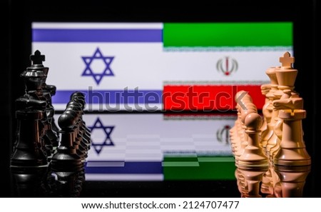 Conceptual image of war between Israel and Iran using chess pieces and national flags on a reflective background