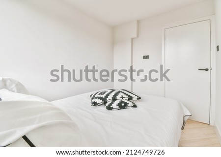 interior of a simple bedroom with double bed with white black pillows