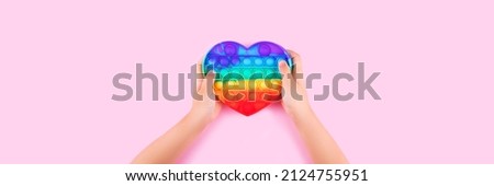 Banner with child's hands holding colored pop it anti-stress toy.