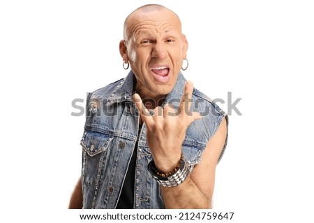 Bald rocker man in a denim vest posing and gesturing rock and roll sign isolated on white background Royalty-Free Stock Photo #2124759647
