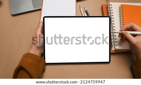 Close-up, Female designer using, designing her graphic image on digital tablet over minimal office desk. top view, working space with female hands drawing on tablet.