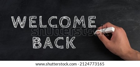 The words welcome back are standing on a chalkboard, reopen post covid-19 pandemic, back to normal, community