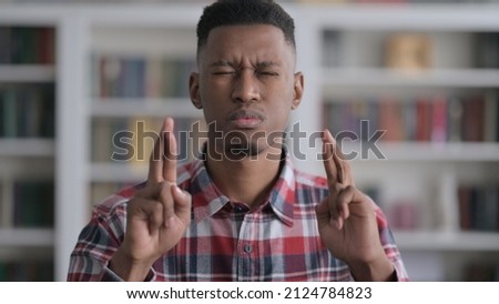 Portrait of African Man Praying with Fingers Crossed