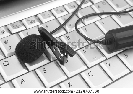 Lavalier microphone on laptop keyboard. Interview and internet streaming concept.