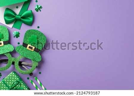Top view photo of the green envelope silk tie bow shimmer funny spectacles confetti in shape of clovers and dots two straws and cute giftbox on isolated violet background copyspace