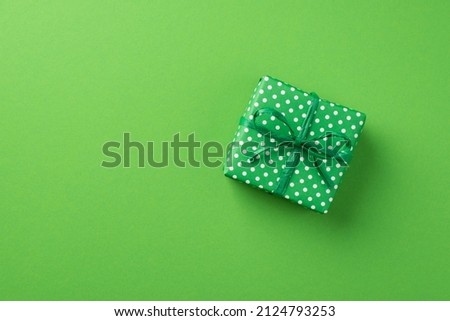 Top view photo of st patrick's day decorations green giftbox with polka dot pattern on isolated pastel green background with copyspace