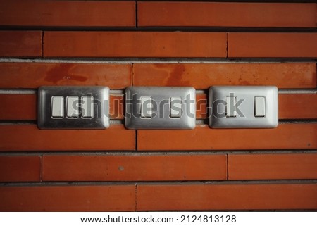 Switch light with stainless cover plate on red brick wall. Royalty-Free Stock Photo #2124813128