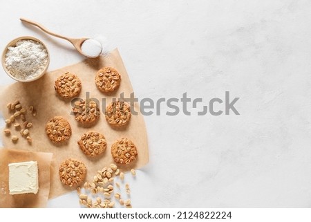 Parchment paper with tasty peanut cookies and ingredients on white background Royalty-Free Stock Photo #2124822224