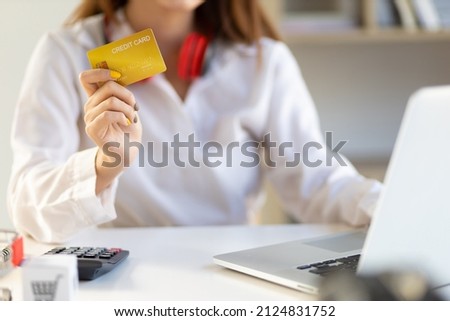 Asian woman holding credit card using laptop and shopping online. Concept of finance and online shopping.