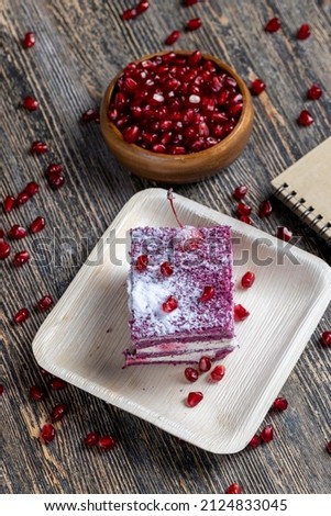 a maroon-colored cake with the taste of different berries and a creamy milk filling of cottage cheese with pomegranate seeds,