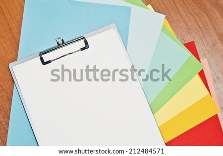 Folder and sheets of colored paper on the table