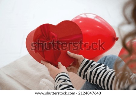 Close up of woman hold gift box red heart for Valentines Day.Delivery present.