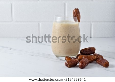 Susu Kurma or Smoothie Dates made from milk and dates or palm fruits. Popular as a Suhoor menu during Ramadan, important to give us energy while fasting. Isolated, copy space for text. Royalty-Free Stock Photo #2124859541