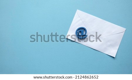 Email marketing concept. A white envelope and email address symbol on blue background with copy space. Royalty-Free Stock Photo #2124862652