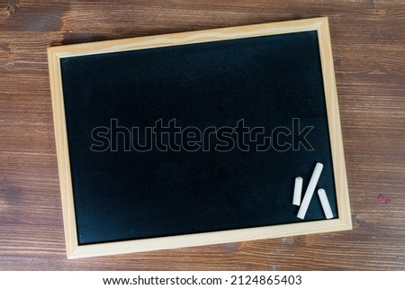 a blank black chalkboard on a wooden surface