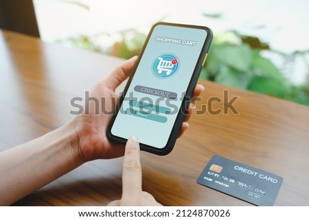 Close up of woman using mobile smart phone with shopping application for buying products and credit card sending massages in the coffee shop