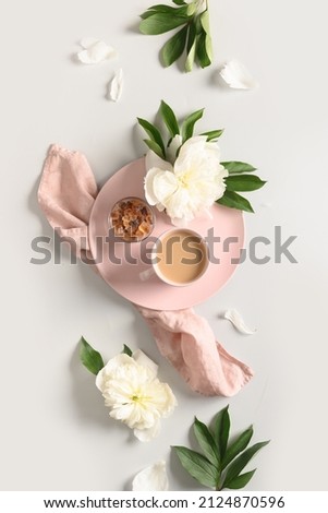 Breakfast with coffee cup and white peonies flowers on gray bckground. View from above, flat lay. Concept nostalgia, memories, tenderness.