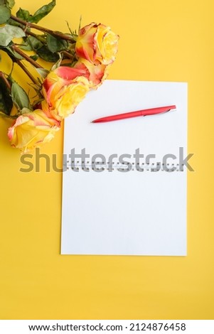 Yellow roses on a yellow background with space for text on a notepad
