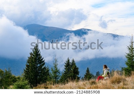 Carpathian hiking trails, female tourist admires Carpathian landscapes, autumn time in the mountains, chornohirskyy ridge.