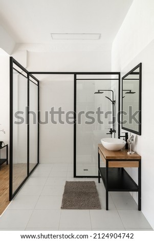 Contemporary bathroom interior design in loft style and transparent partitions. Modern glass shower and white sink with mirror. Luxury apartment for sale Royalty-Free Stock Photo #2124904742