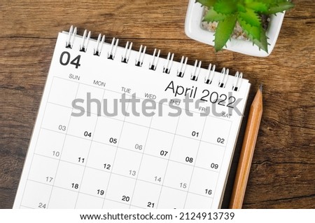 The April 2022 desk calendar with plant on wooden table. Royalty-Free Stock Photo #2124913739
