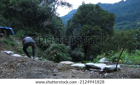 Cianjur, Indonesia - Feb 06 2022 : Locals working on a road with landslide or jalan longsor