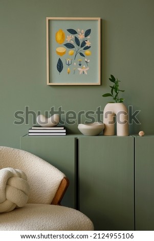 Elegant living room interior design with mockup poster frame, modern frotte armchair, wooden commode and stylish accessories. Eucalyptus wall. Template. Copy space. Royalty-Free Stock Photo #2124955106