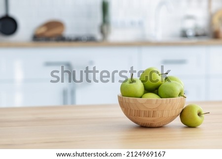 Fresh green apples in a wooden bowl on a wooden table witj copy space. Healthy eating