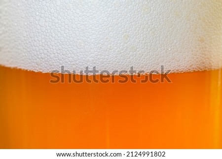 Foam from beer in glass with bubbles photographed in studio