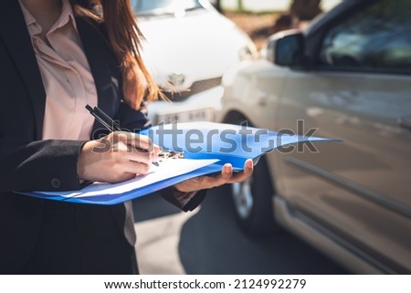Woman notify insurance agents is writing an accident car crash report, to people and transportation insurance concept. Royalty-Free Stock Photo #2124992279