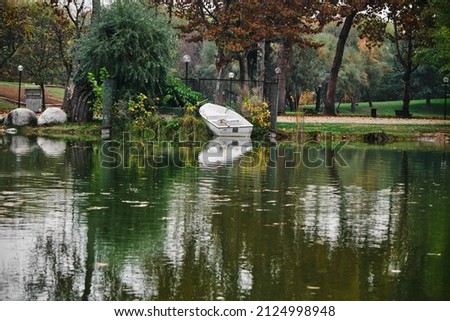 Botanical park in Bursa and small pond at the middle of natural park and small plastic boat and its reflection on white water.