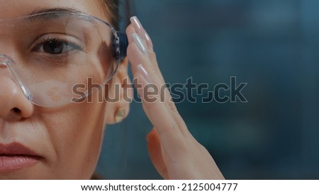 Microbiologist using protective glasses with virtual reality in laboratory. Woman chemist wearing goggles with 3d simulation vision to do scientific research for development. Close up Royalty-Free Stock Photo #2125004777