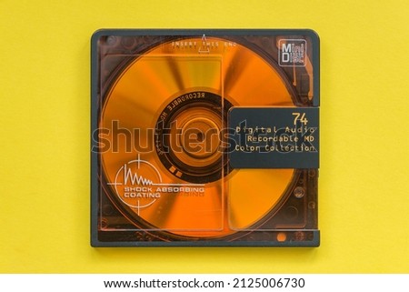Mini disc from the 1990's. Close up view from above with bright yellow background. Royalty-Free Stock Photo #2125006730