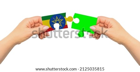 Woman hands are holding part of puzzle game. National mock up on white background. Ethiopia