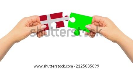 Woman hands are holding part of puzzle game. National mock up on white background. Denmark