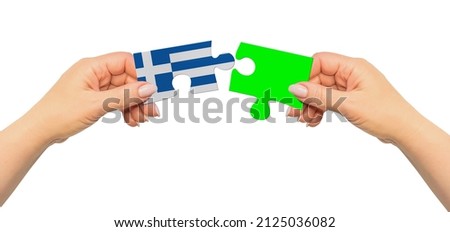 Woman hands are holding part of puzzle game. National mock up on white background. Greece
