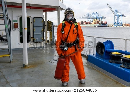 Fireman. Fire fighting equipment. Fire drill. Seaman with fire-fighter’s outfits and Breathing apparatus. Royalty-Free Stock Photo #2125044056