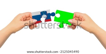Woman hands are holding part of puzzle game. National mock up on white background. Slovenia