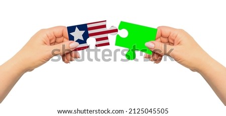 Woman hands are holding part of puzzle game. National mock up on white background. Liberia