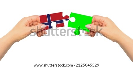 Woman hands are holding part of puzzle game. National mock up on white background. Norway