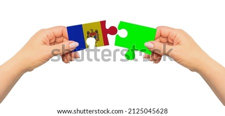 Woman hands are holding part of puzzle game. National mock up on white background. Moldova