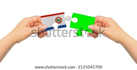 Woman hands are holding part of puzzle game. National mock up on white background. Paraguay