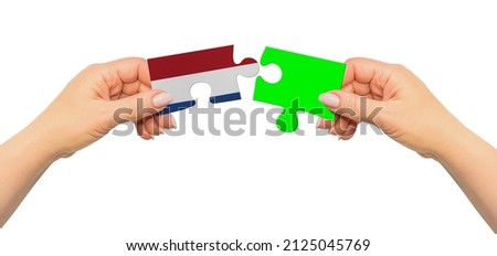 Woman hands are holding part of puzzle game. National mock up on white background. Netherlands