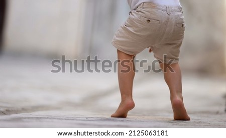 Child walking on tiptoes outside Royalty-Free Stock Photo #2125063181