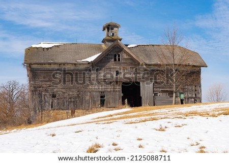 Old wooden barn in rural Midwest on a beautiful Winter morning.
