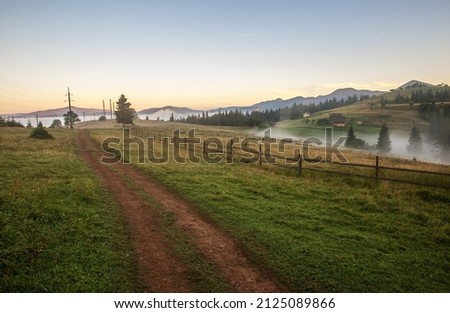 Road is high in the mountains, fields, forests and farmland on the background of a blue sky, Carpathians, Ukraine Royalty-Free Stock Photo #2125089866